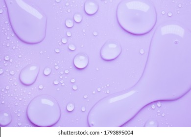Cosmetic moisturizing liquid drops on purple lavender pastel background. Toner or lotion. Hyaluronic serum