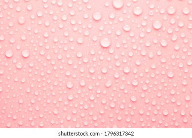 Cosmetic moisturizing liquid drops on light red pink background. Toner or cleanser lotion. Hyaluronic serum