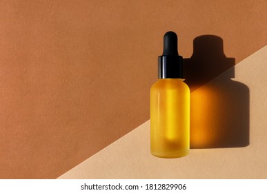 Cosmetic Oil Bottle, Double Diagonal Background. Horizontal Mockup, Banner, Poster, Copy Space. Yellow Serum, Extract, Emulsion, Eco Lotion. Brown Terracotta Colors. Hard Light, Dark Shadow, Flat Lay