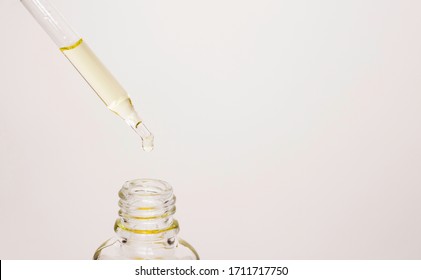 Cosmetic Oil Drips From A Pipette Into A Glass Jar. Oil For Hair And Skin. Spa Treatments, Skin And Hair Care.