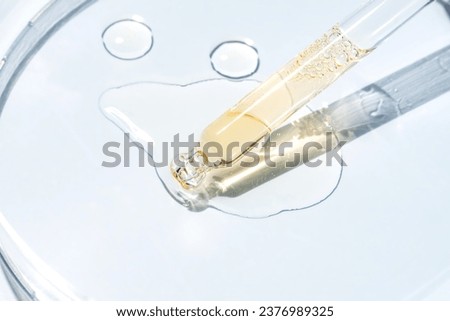 Cosmetic pipette with oil on blue background close-up. Stylish concept of organic essences, beauty and health products. Modern apothecary. Close up