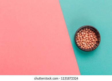 Cosmetic Powder Balls On Color Block Background Top View