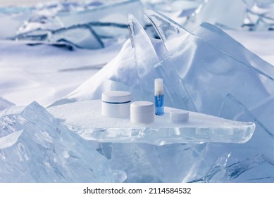 Cosmetic products for face   hand skin care in winter time  Advertising nourishing cosmetics for cold weather podium stand from piece ice against the backdrop frozen   snowy lake