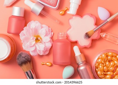 Cosmetic products. Pink bottles and tubes with dispensers, beauty blender, rejuvenation capsules, heart-shaped blush, brushes, cream, essence