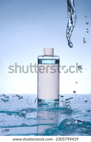 Cosmetic products in water splash on blue background. Skin care cleansing toner or lotion in white bottles and tube falling in water surface.  Empty packaging mock up banner. Mockup of bottles.
