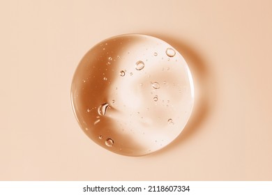 Cosmetic serum gel beauty oil drop on color background. Skin care product droplet with bubbles texture macro