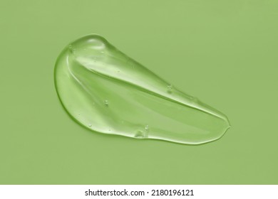 Cosmetic Serum Gel Beauty Swatch Smear Smudge On Green Color Background. Skincare Beauty Product With Bubbles Texture.