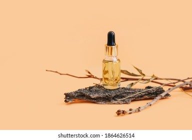 Cosmetic skin care product on tree bark. Natural cosmetics concept. Light warm peach colored background