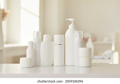 Cosmetic Skin Care Products Of New Female Bodycare Line For Health, Beauty And Wellbeing. White Mockup Lotion Bottles, Cream Jars And Soap Dispenser Standing In Row On Table Or Shelf In Beauty Parlour