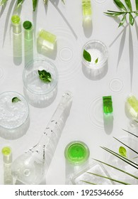 Cosmetic skincare background. Herbal medicine with green leaves. Natural sunlight, long shadows. Splashes of water, splashes. Chemical glassware, petri dishes, vials. Natural skincare background.