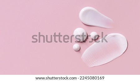cosmetic smears cream texture on pastel pink background