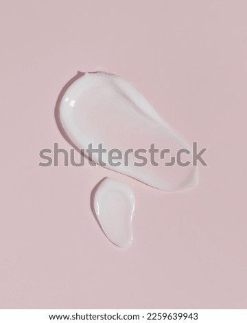 Cosmetic smears cream texture on pink background. Cosmetic skincare product texture. Face cream, body lotion swipe swatch.