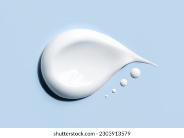 cosmetic smears of creamy texture on a blue background - Shutterstock ID 2303913579