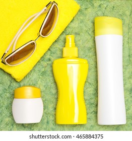 Cosmetic sunscreen products for face and body skin care, towel and sunglasses. Lotion, spray and cream. Cosmetics containing sun protection factor