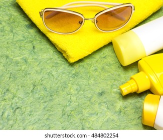 Cosmetic sunscreen products for face and body skin care, towel and sunglasses. Lotion, spray and cream. Cosmetics containing sun protection factor. Copy space