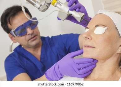 A Cosmetic Surgeon Doctor Giving Fractional CO2 Laser Skin Treatment To The Face Of A Senior Female Woman Patient