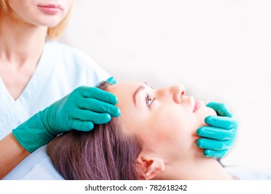 Cosmetic Surgeon Examining Female Client In Office. Doctor Checking Woman's Face, Nose Before Plastic Surgery. Surgeon Or Beautician Hands Touching Woman Face. Rhinoplasty