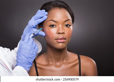 Cosmetic Surgeon Injecting African American Girl Face On Black Background