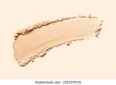 Cosmetic texture bronzer pressed powder smudge with shimmer isolated on light beige background