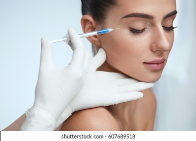 Cosmetic Treatment. Closeup Beautician Hands Doing Facial Skin Lifting Injection To Woman's Face. Beautiful Female With Closed Eyes Receiving Beauty Procedure Indoors. Plastic Surgery. High Resolution