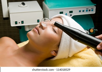 Cosmetician Applying High Frequency Treatment To The Face Of A Young Beautiful Woman