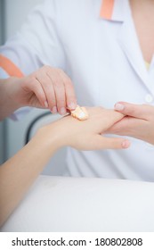Cosmetician beautician applying orange moisturizing cream balm on hands of female client. Skincare. Woman in healthy beauty spa salon. - Shutterstock ID 180802808