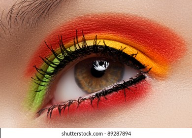 Cosmetics And Beauty Care. Macro Close-up Of Beautiful Green Female Eye With Bright Fashion Runway Make-up. Rainbow Eyeshadows And Black Eyeliner