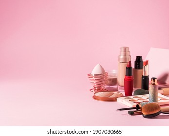 Cosmetics beauty make up products background on pink. Foundation, lipstick, eye shadows, brushes, face powder, eyeliner