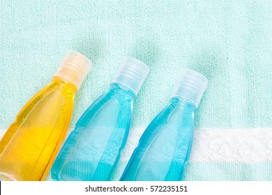 Cosmetics bottles mock ups with shower gel, body moisturizing lotion or herbal shampoo on bath towel background. Bathroom accessories wallpaper