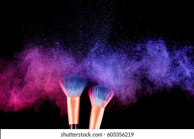 Cosmetics brush and explosion colorful makeup powder background