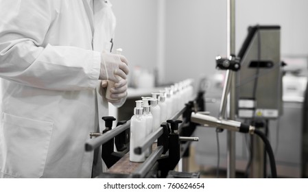 Cosmetics fabric worker taking one liquid soap from a row on a fabric line.