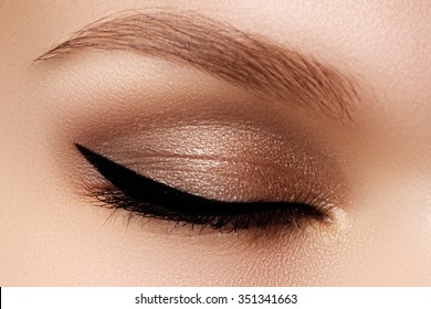 Cosmetics & make-up. Beautiful female eye with sexy black liner makeup. Fashion big arrow shape on woman's eyelid. Chic evening make-up