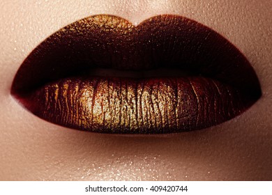 Cosmetics and make-up. Shoot of a beautiful girl with golden lips lipstick and gloss. Sexy and stylish lips. Lips against the backdrop of smooth skin