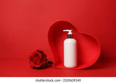 Cosmetics, Moisturizer, Shampoo Bottle Staying In Heart With Flower Rose On Red Background. Valentine's Day, Skin Care With Love