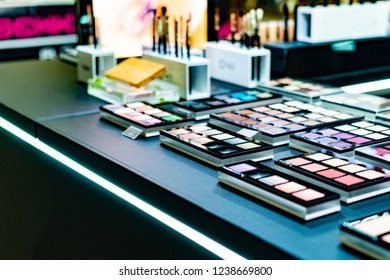 Cosmetics On The Shop Window With A Variety Of Colors And Shades, Mascara, Powder, Paint For Beauty And Makeup. Consumerism, Retail And Purchase Concept.