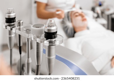 A cosmetologist applies anesthetic cream to a young woman's face before a facial cosmetic procedure. Anesthetic cream. Preparation for healing, tightening, skin rejuvenation in beauty salons. - Shutterstock ID 2365408231