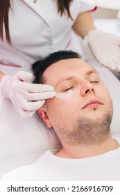 Cosmetologist Applying Anesthetic Cream On Man Face In Beauty Salon. Aesthetic Medicine