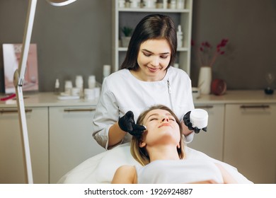 Cosmetologist Applying Cream Essence Essential Vitamins Into Face To Improve Client Skin. Beauty Expert Makes Beauty Treatment For Patient. Health, Skin Care, Aethetic Medicine Concept