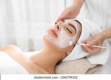 Cosmetologist applying mask on client's face in spa salon - Shutterstock ID 1342799132