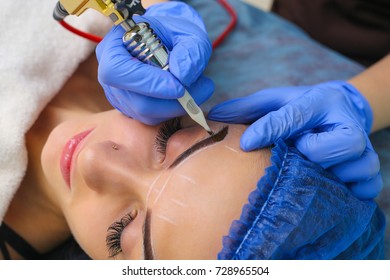 Cosmetologist applying permanent make up on eyebrows- eyebrow tattoo