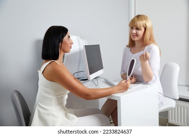 Cosmetologist consulting female patient in medical esthetic office - Shutterstock ID 2233824637
