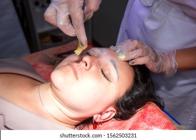 The cosmetologist corrects the eyebrows of the client by the method of shugaring. close-up.