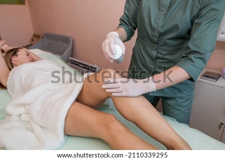 Cosmetologist disinfects feet with spray before sugaring. Smooth legs concept
