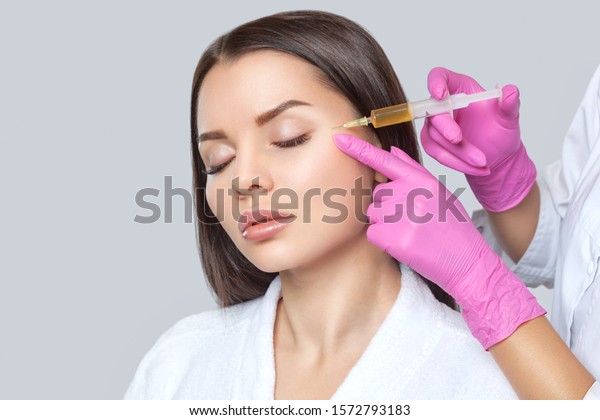 Cosmetologist does prp
therapy on the face of a beautiful woman with clean skin in a
beauty salon. There is in vitro blood plasma, ready for injection.
Cosmetology
concept.