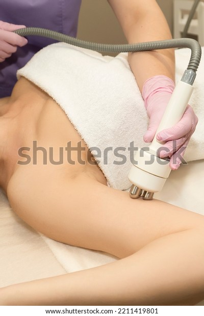 Cosmetologist doing radio\
frequency arm lift for skin laxity treatment, woman getting radio\
frequency skin tightening on the inner surface of the arm in a\
beauty salon, 