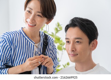 Cosmetologist And Japanese Man Trimming Eyebrows
