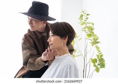 Cosmetologist And Japanese Man Trimming Eyebrows
