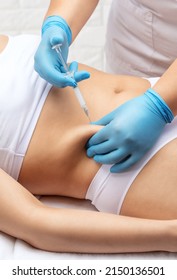 cosmetologist makes lipolytic injections to burn fat on the stomach and waist of a woman. Female aesthetic cosmetology in a beauty salon.Cosmetology concept.cosmetologist makes lipolytic injections to