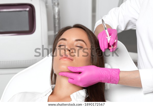 Cosmetologist makes rejuvenating anti wrinkle\
injections on the face of a beautiful woman. Female aesthetic\
cosmetology in a beauty\
salon.