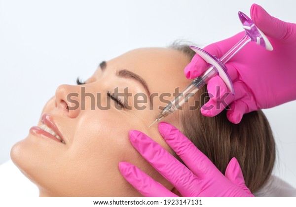 Cosmetologist makes rejuvenating anti wrinkle\
injections on the face of a beautiful woman. Female aesthetic\
cosmetology in a beauty\
salon.\
